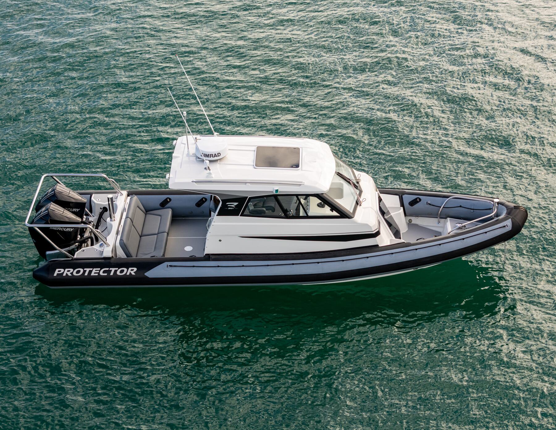 Protector 310 Targa running at speed on open water with its enclosed pilothouse visible