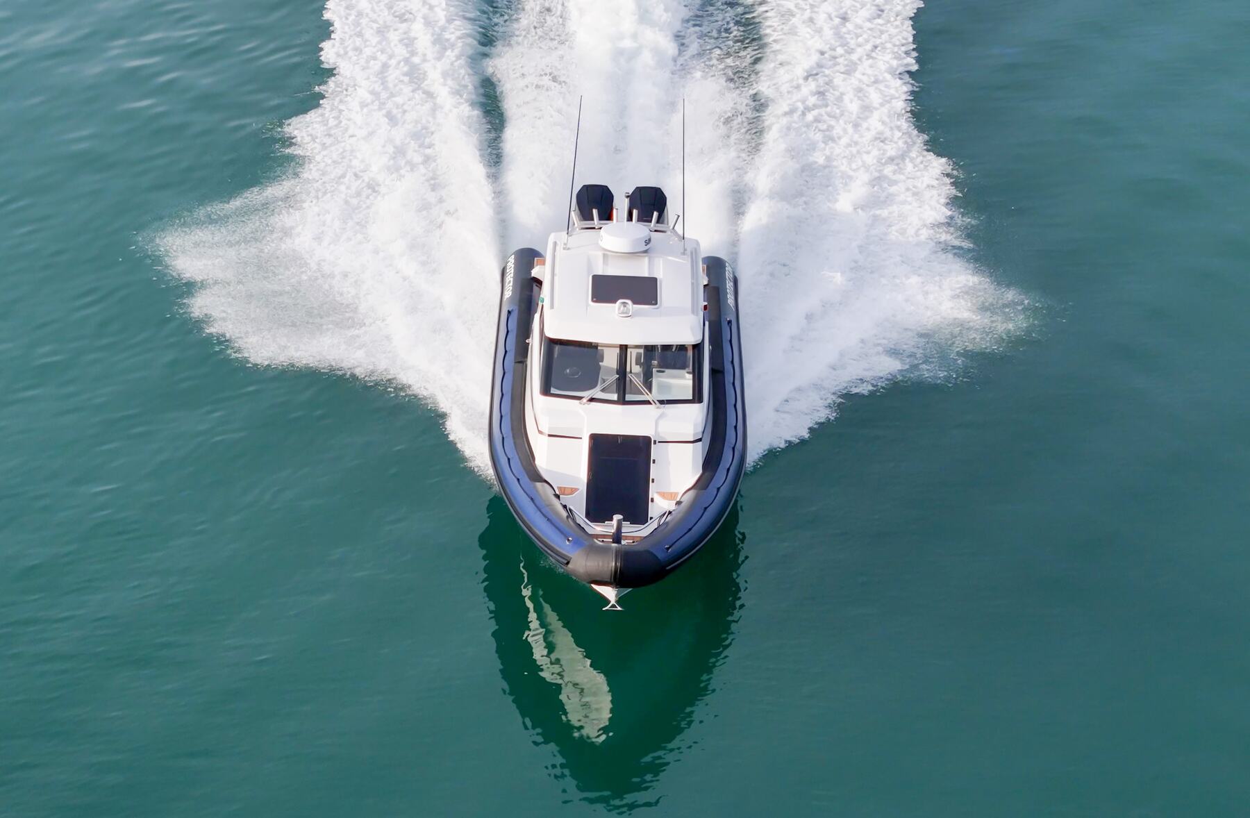 Aerial view of a Protector Targa running at speed, wake spreading behind it