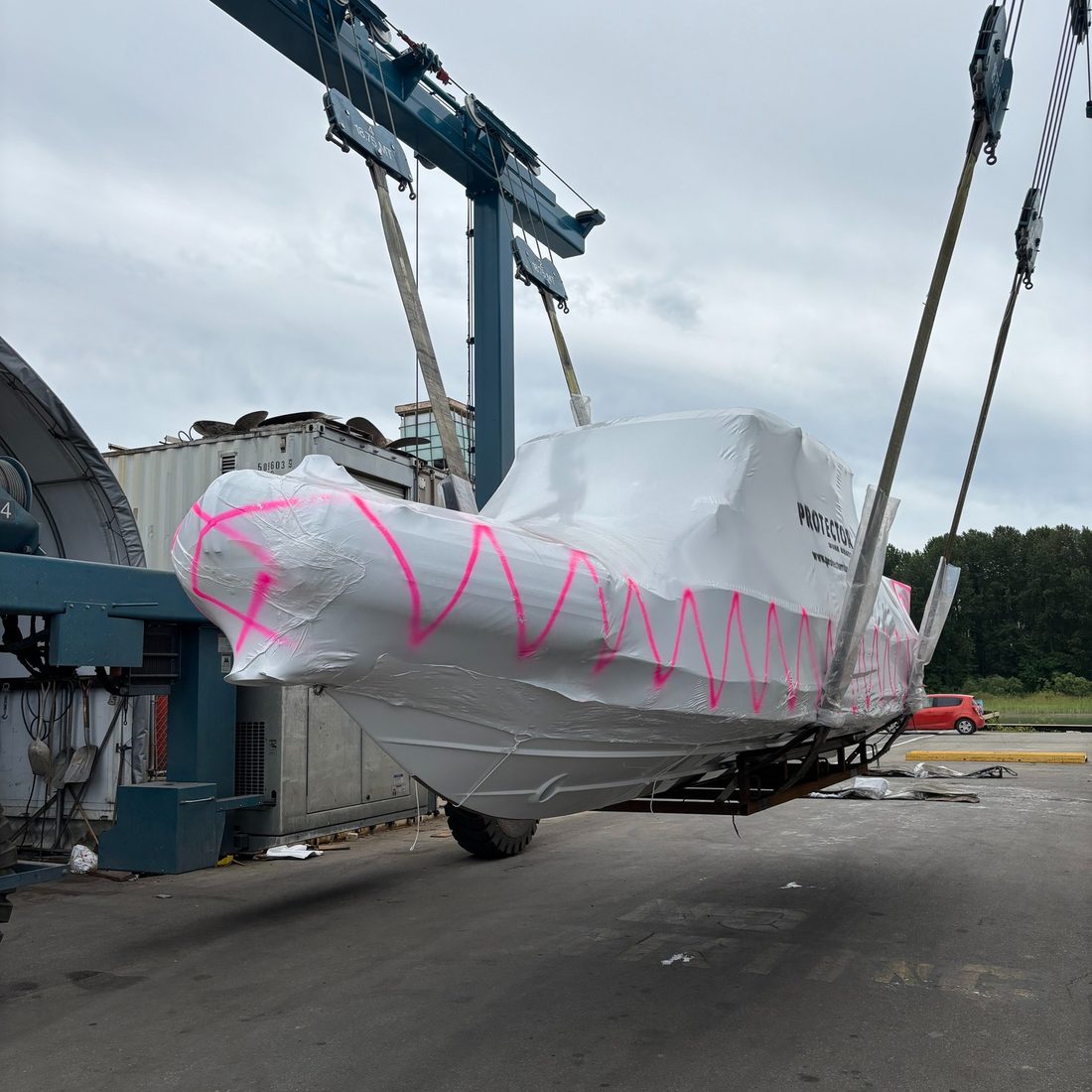 A shrink-wrapped Protector being lifted by travel hoist at the yard