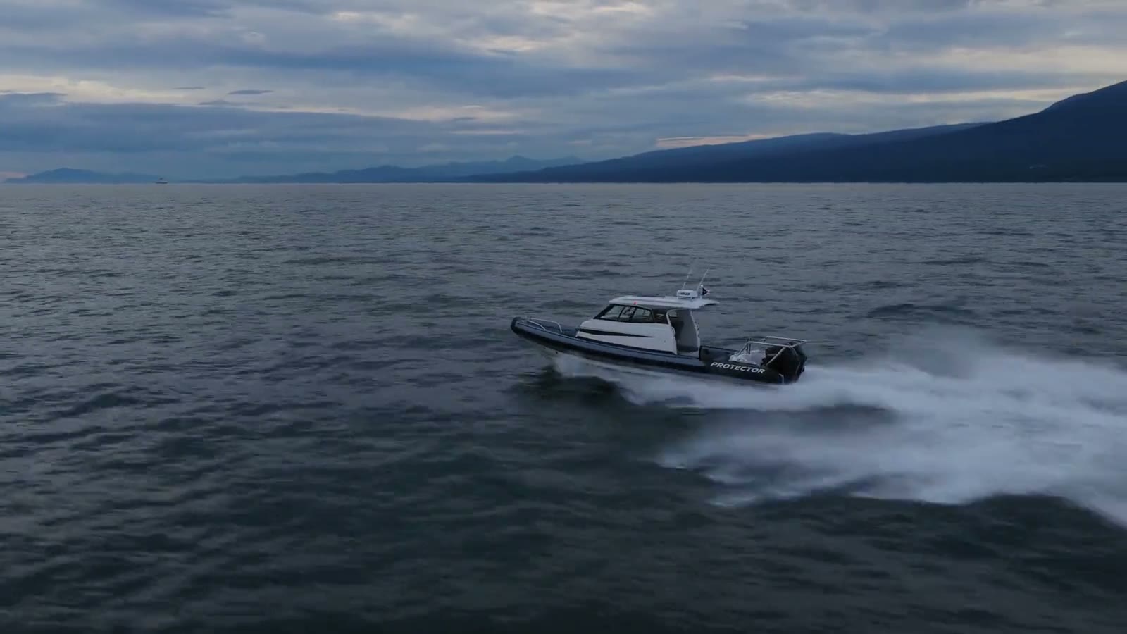 A Protector RIB running at speed across open water