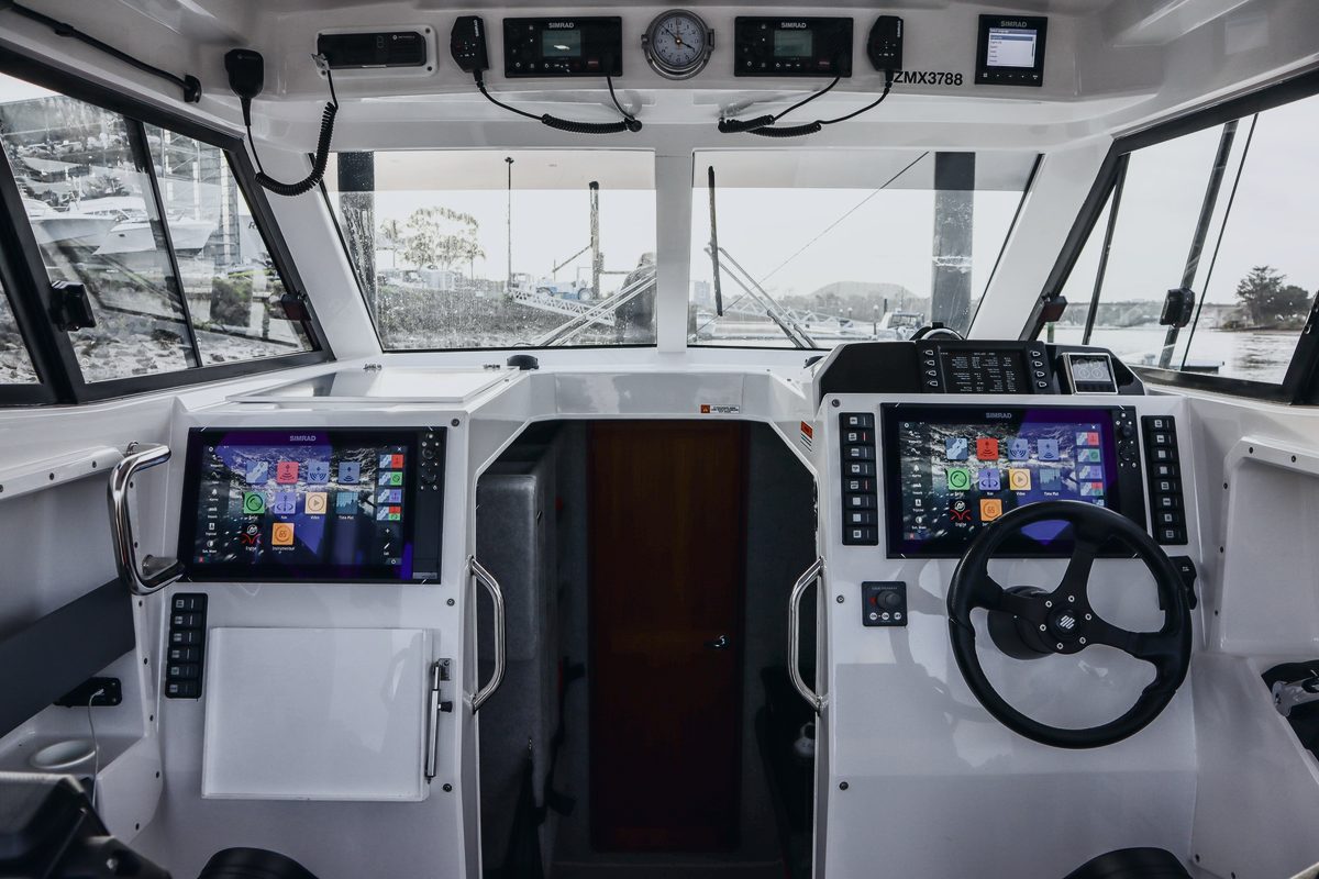 The helm of a Protector Targa, with twin multifunction displays and the cabin door behind